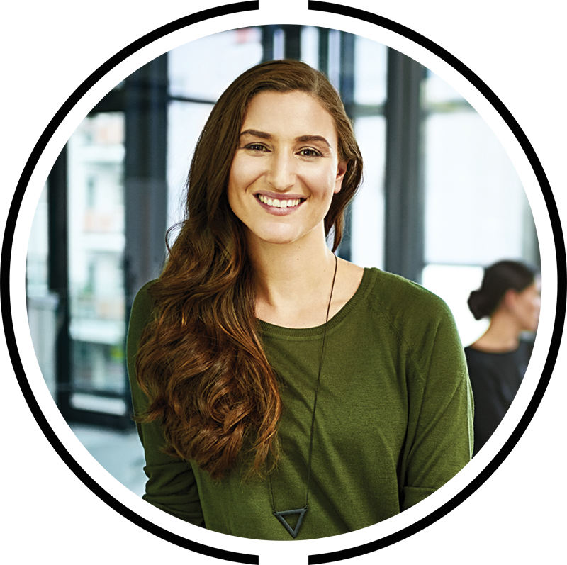 Smiling woman looking directly at the camera, sitting in a corporate office